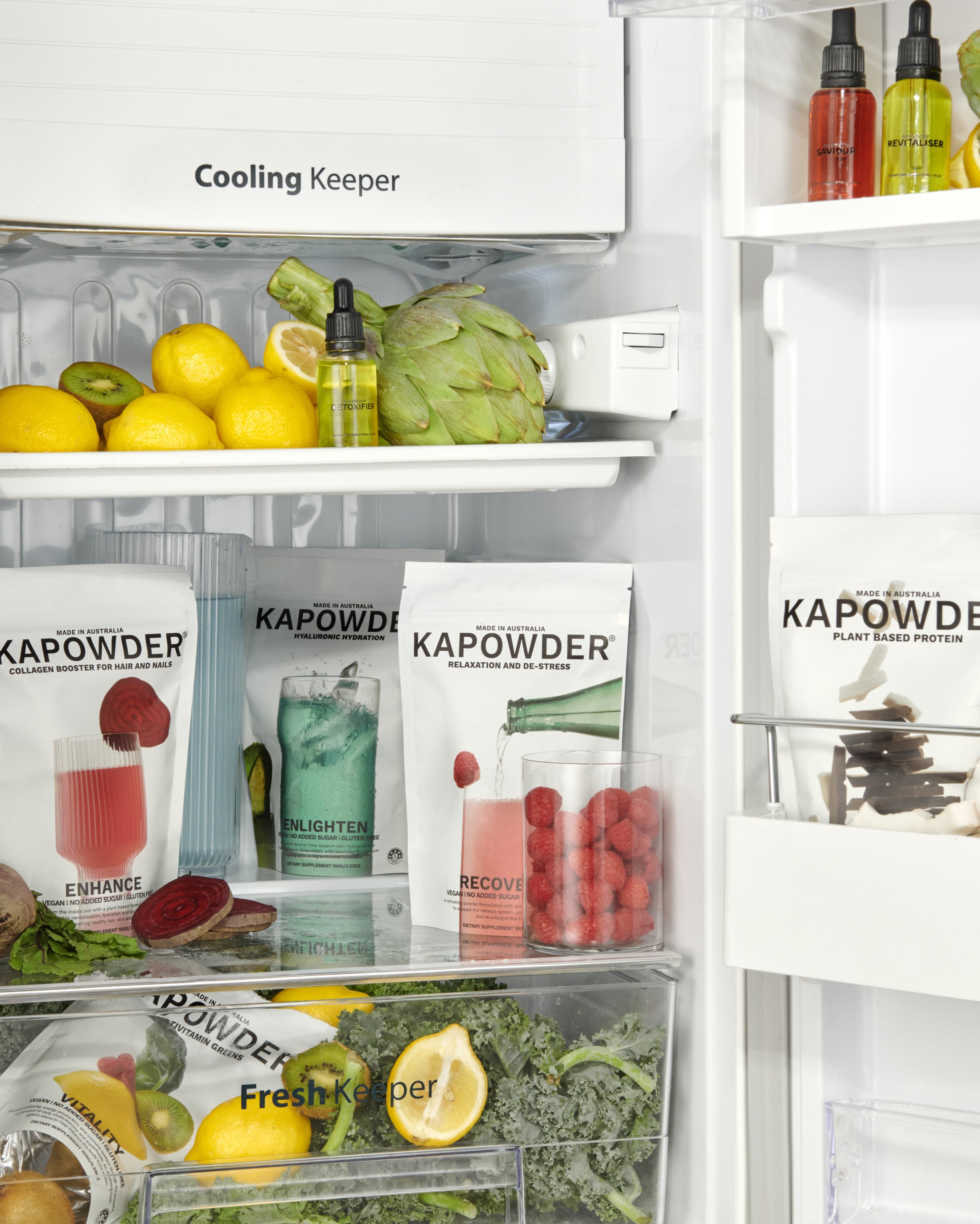 Image of KAPOWDER products in a fridge surrounded by fruit and vegetables highlighting nutrients and vitamins available in the products.